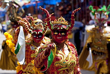 Diablada dancers wearing elaborate devil masks and costumes in the procession of the Carnaval de Oruro, Oruro, Bolivia