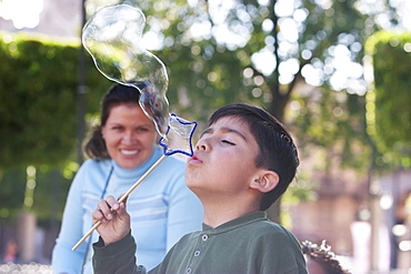 Boy blowing soap bubbles at Plaza de Armas (Plaza de los Murtires), Morelia, Michoacun, Mexico