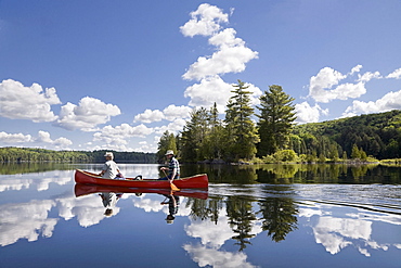 Senior couple canoeing on Smoke Lake, Algonquin Park, Ontario