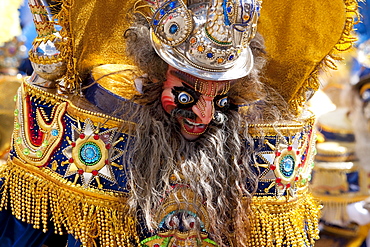 Morenada dancer wearing an elaborate mask and costume in the procession of the Carnaval de Oruro, Oruro, Bolivia