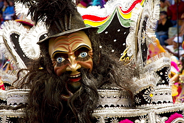 Morenada dancer wearing an elaborate mask and costume in the procession of the Carnaval de Oruro, Oruro, Bolivia