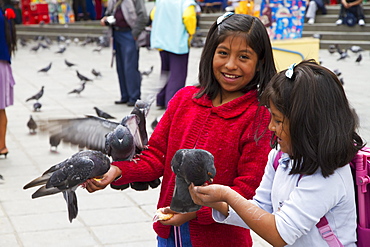 Girls feeding pigeons on Plaza Murillo, La Paz, Bolivia