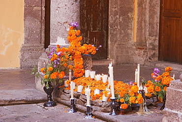 Dia de los Muertos, the Day of the Dead altar at the Regional Museum of Michoacun in Morelia. These altars usually have the Christian cross, pictures of deceased persons, and scores of candles. Ofrendas (offerings) usually include foods such as candied pumpkin, pan de muerto (bread of the dead), sugar skulls and beverages such as atole., Michoacun, Mexico