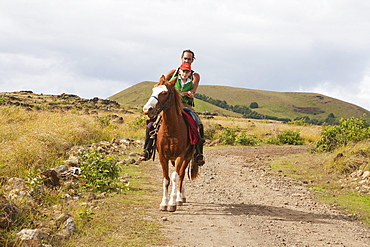 Man and boy on horseback by Ahu Tepeu, Rapa Nui (Easter Island), Chile