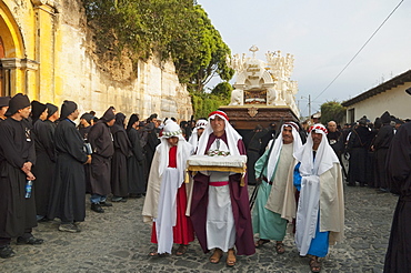 Men dressed in mourning carrying the anda (float) of the Last Supper during the Holy Burial Procession on Good Friday in Antigua Guatemala, Sacatepuquez, Guatemala