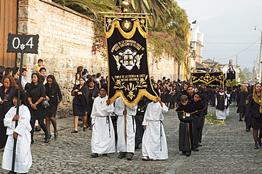 Boys carrying standards in front of the anda (float) of the sorrowful Virgin Mary during the Holy Burial Procession on Good Friday in Antigua Guatemala, Sacatepuquez, Guatemala