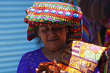 Maya woman selling embroidered table cloths at the Sunday Market in Chichicastenango, El Quichu, Guatemala