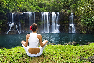 Hawaii, Kauai, Woman sitting near Kilauea Falls, View from behind.