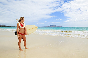 Hawaii, Oahu, Kailua Beach, Teenage girl holding surfboard on beach.