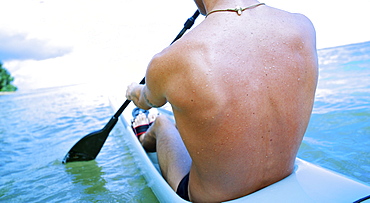 Hawaii, Kauai, Anini Beach, Active male paddling in a one man canoe.