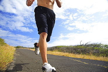 Hawaii, Oahu, Makapu'u, Athletic male running along the makapuu hiking trail, closeup of feet