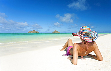 Hawaii, Oahu, Lanikai Beach, Woman relaxing along sandy shore.