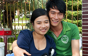 South East Asia, Vietnam, Hanoi, Student couple relaxes on college campus for their portrait.