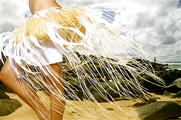 Hawaii, Kauai, Kealia, Beautiful Hawaiian girl dancing hula on ocean shoreline.