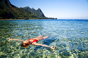 Hawaii, Kauai, Tunnel's beach, Woman floats in the ocean.