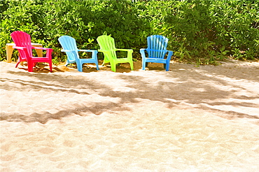 Hawaii, Kauai, Pila'a, Four colorful chairs rest on the sand.