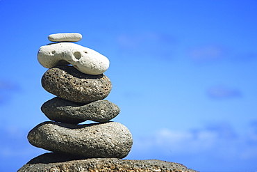 Hawaii, Oahu, Spa element of rocks stacked up against a blue sky.