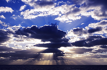 Hawaii, Late afternoon rain clouds over ocean horizon.