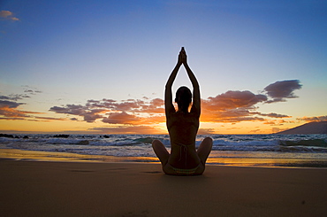 Hawaii, Maui, Silhouette of beautiful girl doing yoga on the beach.