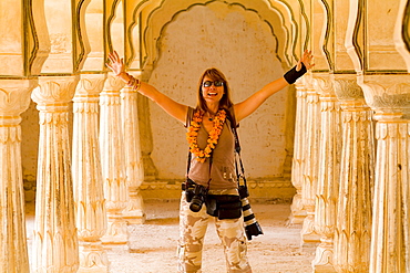 India, Rajasthan, Jaipur, Female tourist with lots of cameras at Amber Fort.