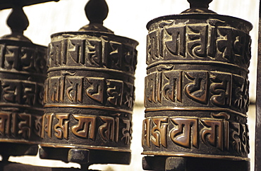 Nepal, Kathmandu, Swayambhunath Temple, closeup of prayer wheels with carvings.