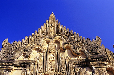 Burma (Myanmar), Bagan, Tayyukpye Temple, detail of Stucco Reliefs on top, blue sky.