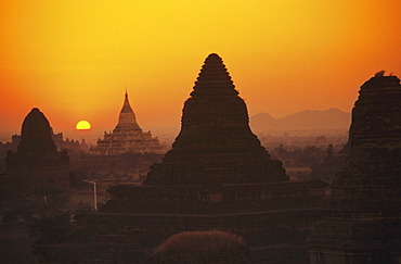 Burma (Myanmar), Bagan, Shwesandaw Paya, temples silhouetted against orange sunset.