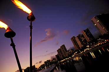 Hawaii, Oahu, Waikiki lights at night with tiki torches.