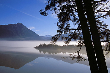 Alaska, Juneau, Mendenhall Glacier, Tongass National Forest, Mountains reflect in a mountain lake.