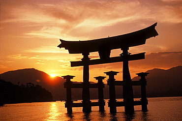 Japan, Kyushu, Miyajima torii gate in water, Itsukushima Shrine, peaceful sunrise