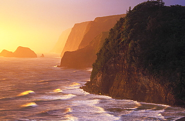 Hawaii, Big Island, North Kohala, Pololu coast and warm glowing surf sunrise,