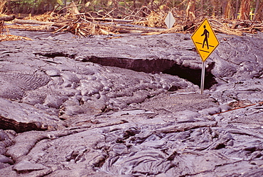 Hawaii, Big Island, Kalapana, Harry K. Brown Park, pedestrian crossing sign covered by lava