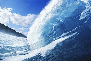 Side view of blue, curling wave.