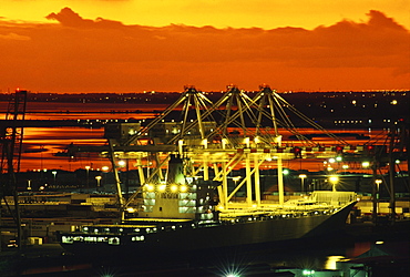 Hawaii, Oahu, Bright lights of a container ship at dusk in Honolulu Harbor.