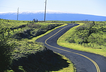 Hawaii, Big Island, Saddle Road curves it's way towards snowcapped Mauna Loa.