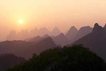 China, Guilin, Piled Silk Mountains, at sunset, orange sky B1785