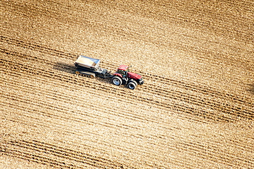 Aerial view of a tractor in a field pulling a grain wagon loaded with freshly harvested soybeans in Kent County; Rock Hall, Maryland, United States of America