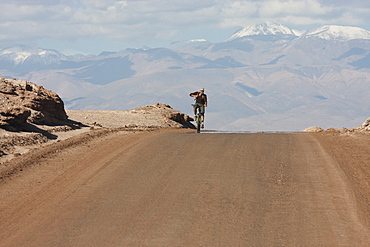 Man On A Mountain Bike Travelling Through The Valle De La Luna (Moon Valley), San Pedro De Atacama, Antofagasta Region, Chile