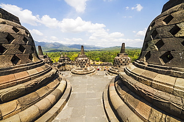 Latticed stone stupas containing Buddha statues on the upper terrace, Borobudur Temple Compounds, Central Java, Indonesia