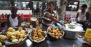 Indian men selling savoury snacks from a street food stall