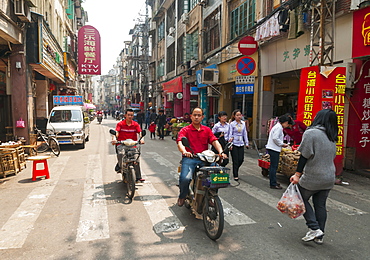 Cyclists and pedestrians at the traditional street market, Xiamen, Fujian province, China