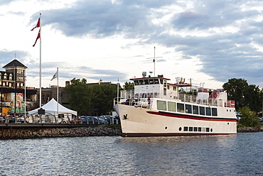 A tour boat moored along the shoreline of Lake of the Woods at sunset, Kenora, Ontario, Canada