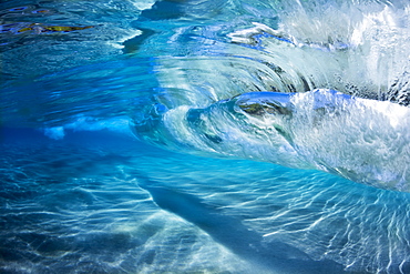 Underwater view of the blue water of the surf crashing over a sandy bottom, Maui, Hawaii, United States of America