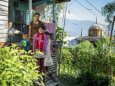 A mother with four children standing on the steps of their home near the Glenburn Tea Estate, West Bengal, India