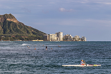 View of Diamond Head, Waikiki, and the two major Hawaiian watersports outrigger canoeing and surfing, from Magic Island, Ala Moana Beach Park, Honolulu, Hawaii, United States of America