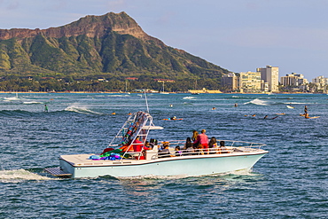 View of Diamond Head, Waikiki, a Hawaiian Parasail boat and surfing from Magic Island, Ala Moana Beach Park, Honolulu, Oahu, Hawaii, United States of America