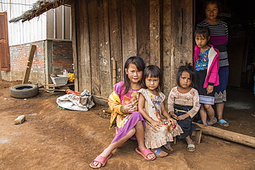 Hmong woman and four girls in front of their house in Na Kam Peng, also called Bomb Village, Xiangkhouang, Laos