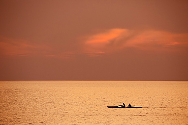 Two people in outrigger canoe at sunset, Kihei, Maui, Hawaii, United States of America