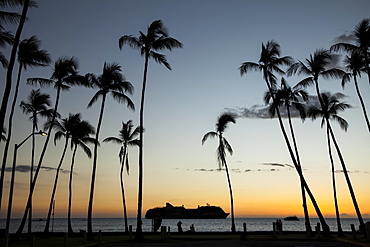 Silhouette of a cruise ship on the water off the shore of Kailua Bay at sunset, Kailua-Kona, Island of Hawaii, Hawaii, United States of America