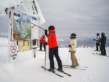 Skiers look at a map at Sun Peaks ski resort, Kamloops, British Columbia, Canada